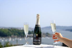 索尔塔什Beautiful Cottage with Sea Views Cornwall的一瓶香槟和一张桌子上的两杯酒