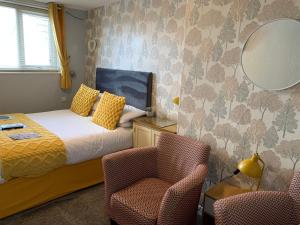 布莱克浦法尔德国际旅馆的一间卧室配有一张床、一把椅子和镜子