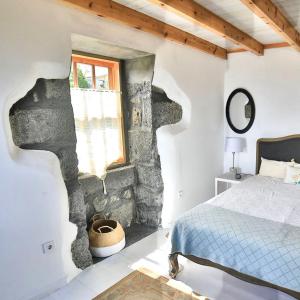 Cais do PicoWaka Waka Pico Azores的一间卧室设有石墙和一张床