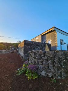 Cais do PicoWaka Waka Pico Azores的鲜花屋前的石墙