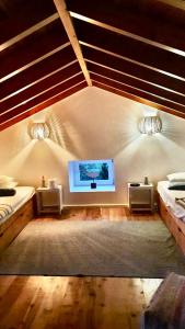 Cais do PicoWaka Waka Pico Azores的一间卧室配有两张床和一台平面电视