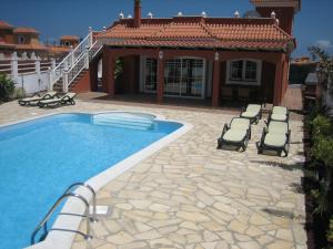 卡勒达德福斯特Verano Brisa Private Golf Villa的一个带躺椅的游泳池以及一座房子