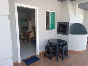 邦比尼亚斯Residencial Brisa do Mar 2的客厅配有桌子和壁炉