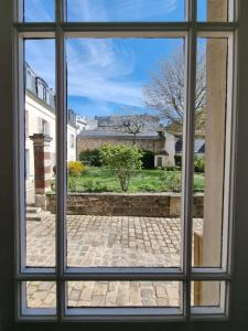 凡尔赛Charmant studio proche du château的开放式窗户享有庭院的景致。