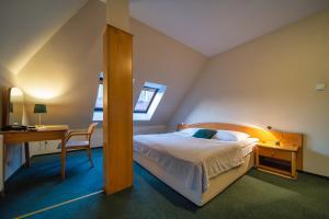 托伦格曼达托瑞酒店的一间卧室配有一张床、一张桌子和一张桌子