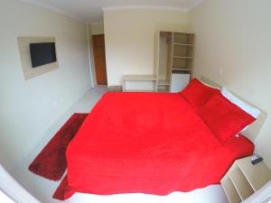 巴拉奈里奥-坎布里乌马格努斯旅馆的一间卧室配有红色的床和红色枕头