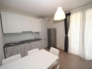 洛萨皮内塔Apartment Veranda-6 by Interhome的厨房配有白色橱柜和白色的桌椅