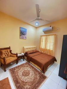 斯里伊斯兰德WawAmir Homestay @ Seri Iskandar的卧室配有床、风扇和地毯。