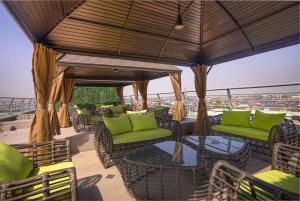 伊凯贾GTA HOTEL IKEJA的屋顶上带绿色桌椅的天井