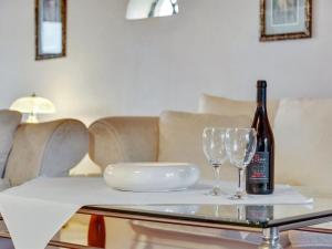 霍耶Apartment Aava - all inclusive - in Western Jutland by Interhome的桌子上放有一瓶葡萄酒和两杯酒