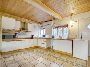 霍耶Holiday Home Evie - all inclusive - in Western Jutland by Interhome的厨房配有白色橱柜和木制天花板