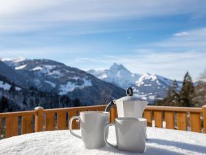 格里翁Chalet Chalet les Pars by Interhome的雪地桌子上放着两个咖啡杯