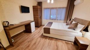 伊斯坦布尔La Pearl Konaklama的一间卧室配有一张床、一张书桌和一台电视