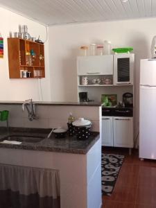 马卡埃Casa da Lu的厨房配有水槽和白色冰箱