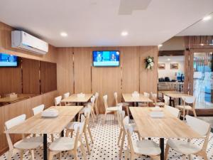Ban Na KhamNakara Hotel, Ubon Ratchathani的配有木桌和白色椅子的餐厅