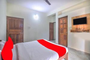 巴加Roseal Water Front的一间卧室设有红色和白色的床和一台电视。