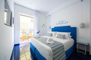 马奥莱4blu Camere Marine的蓝色和白色的卧室设有床和窗户