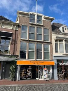 吕伐登Appartement met prachtig uitzicht over de binnenstad van Leeuwarden的一座砖楼前的商店,有橘色的店面
