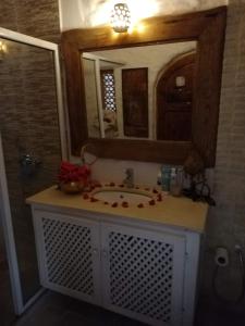 托泽尔Riad Dar El Caid - Palais XIII Siecle的一间带水槽和镜子的浴室