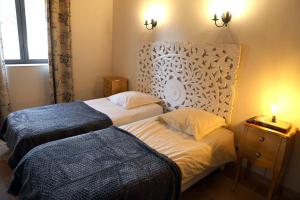 旺德雷Domaine de la Vidalle的一间卧室设有两张床、床头板和窗户。