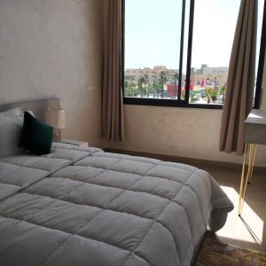 达赫拉Palm D'or-Appartement familial de luxe au centre de Dakhla的一间卧室设有一张大床和一个大窗户