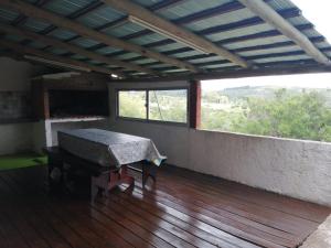 塞拉纳镇Cabaña Jacarandá的客房设有桌子和大窗户。