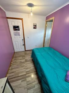 Habitación con baño privado的一间卧室设有一张绿色的床和紫色的墙壁