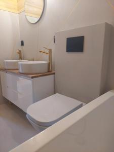 SidzinaNiedźwiedzi Zakątek的浴室设有2个水槽、卫生间和镜子。