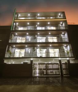 古尔冈Limewood Stay Diamond 2BHK & Studio Huda City Centre & FORTIS的一座高大的建筑,晚上有灯