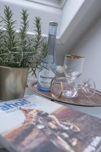 诺德奈Hotel Seehof Norderney OHG的一张桌子,上面放有瓶子、眼镜和杂志