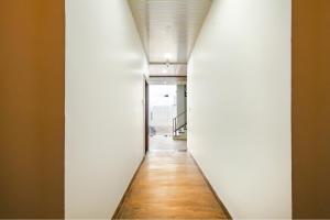 印多尔FabExpress Dream paradise的长长的走廊,设有白色的墙壁和木地板