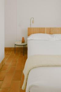 奥良莫德斯塔农家乐的卧室配有白色的床和桌子