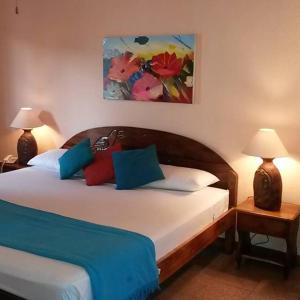 萨玛拉萨马拉海滩酒店的一间卧室配有蓝色和红色枕头的床