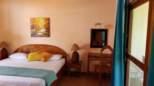 萨玛拉萨马拉海滩酒店的一间卧室配有两张床、一张桌子和一面镜子
