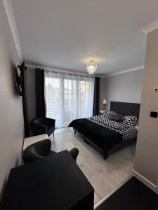 米兹多洛杰Saviano Mare Villa的卧室配有黑白床和椅子