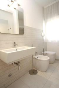 比比翁Dune Dependance的白色的浴室设有水槽和卫生间。