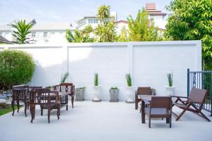 清迈Singharaj Boutique Hotel的一个带桌椅的庭院和白色的墙壁