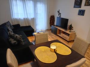 索科矿泉村Apartman Pan的客厅配有桌子和电视
