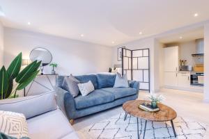 利兹Gorgeous Flat in Central Leeds by PureStay Short Stays的客厅配有蓝色的沙发和桌子