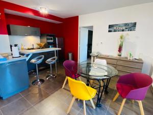 罗德兹Appartement T2 cosy à Rodez的厨房配有玻璃桌和一些椅子
