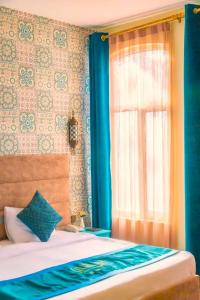 巴库Sahil Inn Baku Hotel Formula 1 View的一间卧室配有床和蓝色窗帘的窗户