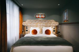 巴黎1,75 Paris La Sève的一间卧室配有一张带橙色枕头的大床