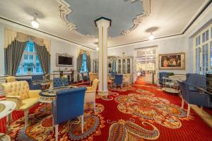 巴特埃姆斯Häcker's Hotel的大房间,设有蓝色椅子和红色地毯