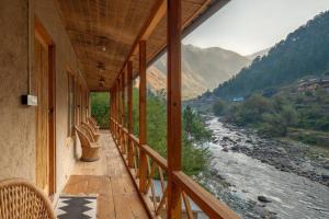 GushainiLiving Good - A Himalayan Boutique Stay的享有河流和山脉美景的阳台。