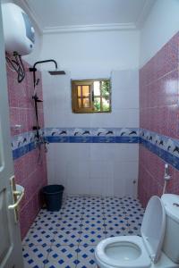洛美Studio meublé R1的浴室设有卫生间,铺有红色和蓝色瓷砖。