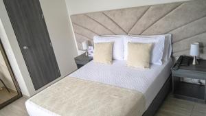 阿纳波伊马HOTEL LE FALEP的卧室配有一张带白色床单和枕头的大床。