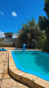 MartinsChácara Tantan - Martins RN的一座绿树成荫的庭院中的蓝色游泳池