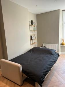 奈梅亨Old Town City Centre Apartment 2的一间卧室配有一张带黑色毯子的床