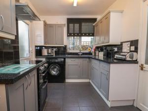霍恩西Sea Front Apartment的厨房配有白色橱柜、洗衣机和烘干机