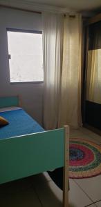 大坎普Casa verde的一间卧室设有床、窗户和地毯。